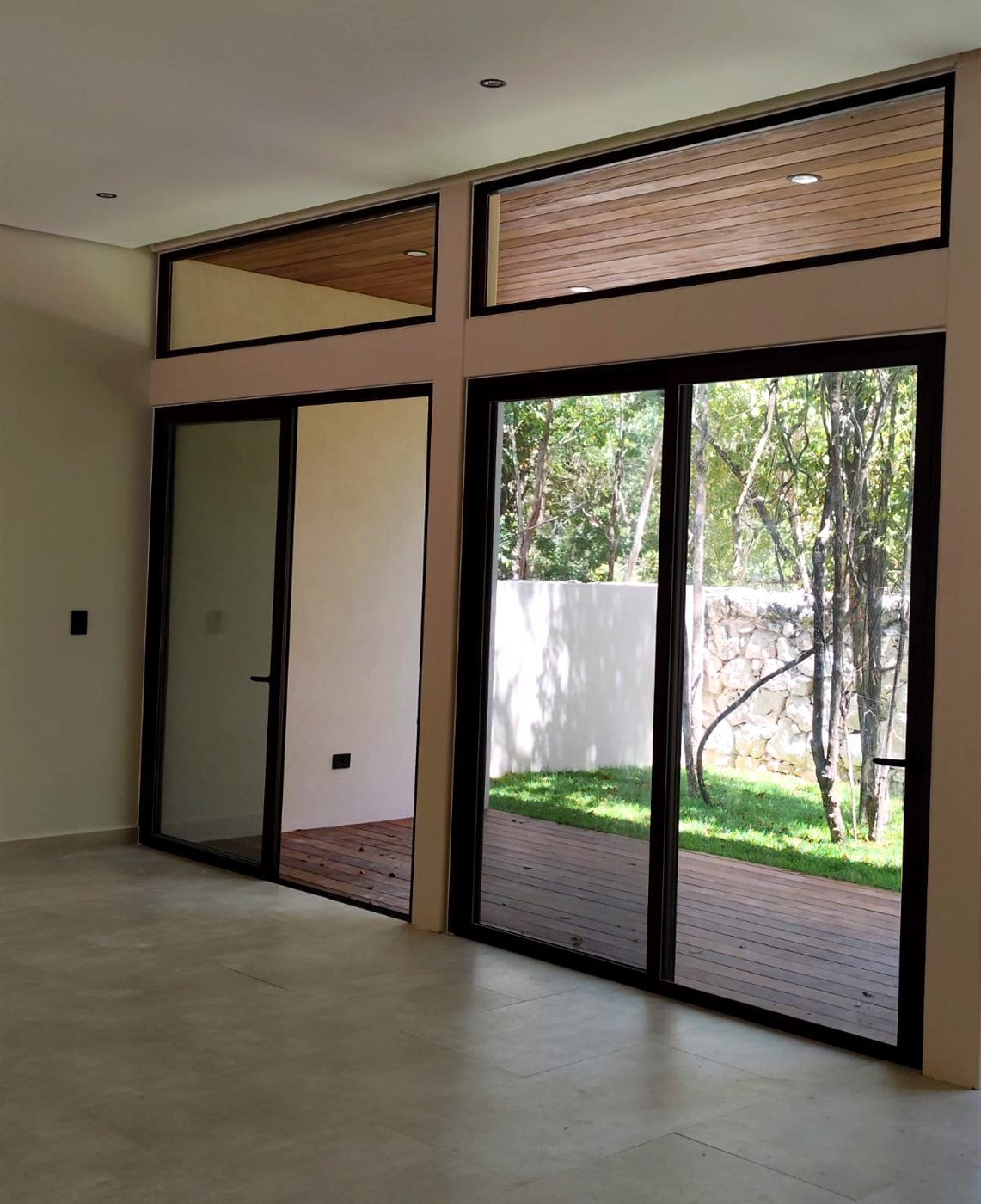 Puertas corredizas de aluminio negro y vidrio con vista al jardín