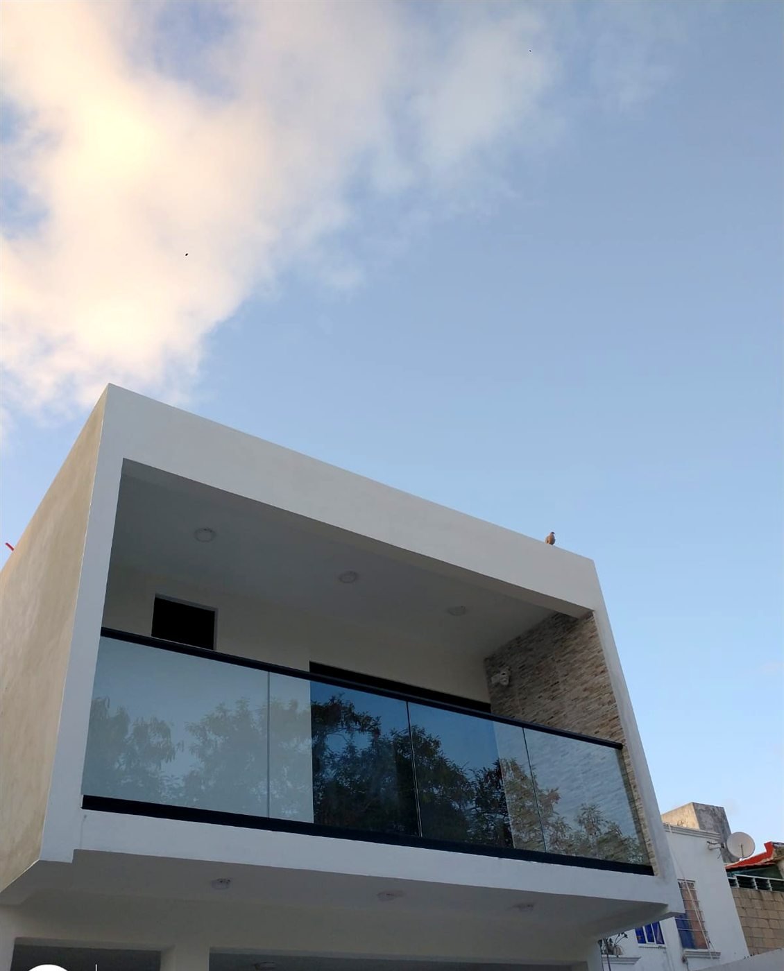Barandal de vidrio templado con zoclo servilletero y pasamanos en balcón